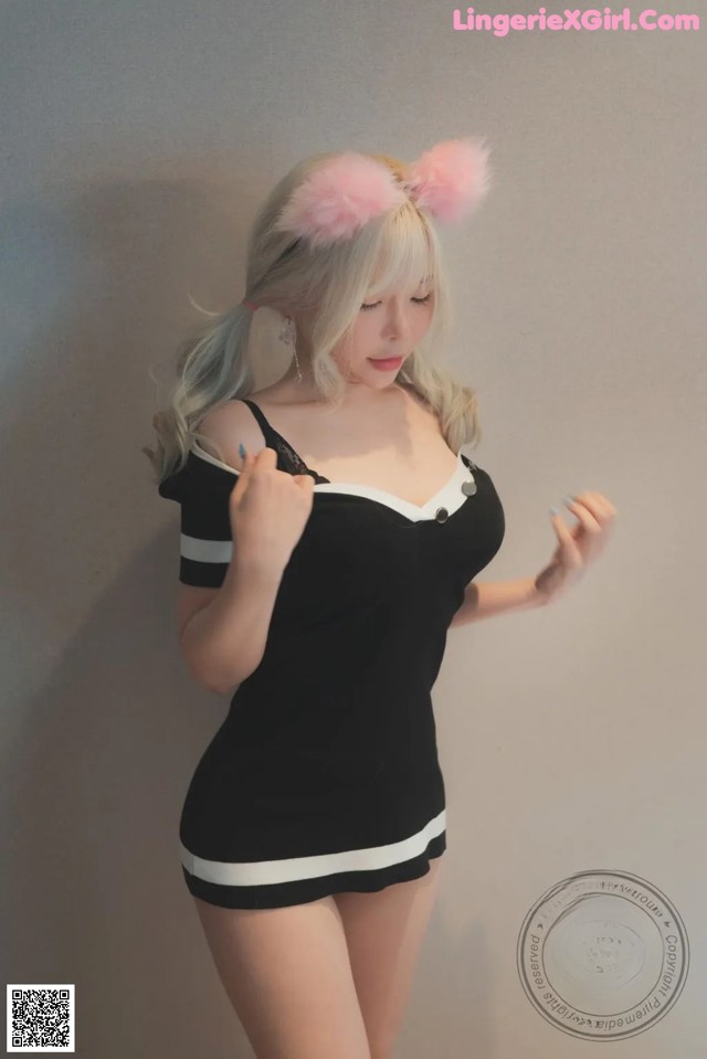 A woman in a black and white dress with pink ears.