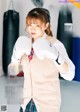 A woman wearing boxing gloves standing in front of a punching bag.