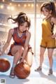 A couple of young women playing basketball on a court.