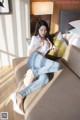 A woman sitting on a couch in a hotel room.