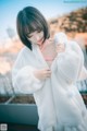 A woman in a white robe is posing for a picture.