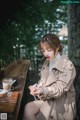 A woman sitting at a table with a cup of coffee.