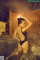 A woman in a black bathing suit standing in a hot spring.