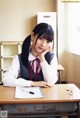 A young woman sitting at a desk in a classroom.